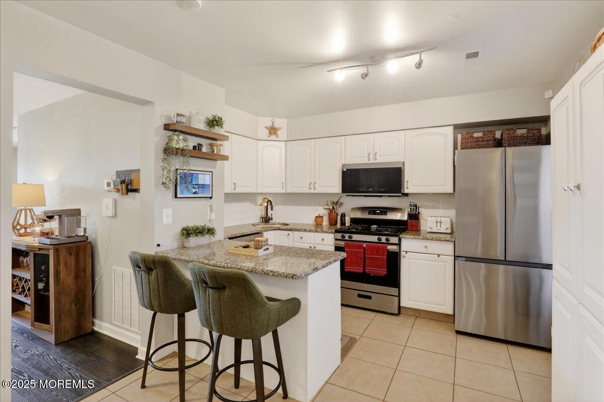73 Rita Lane Jackson, NJ 08527 - Photo 10 of 32 a kitchen with stainless steel appliances granite countertop a refrigerator and a stove top oven