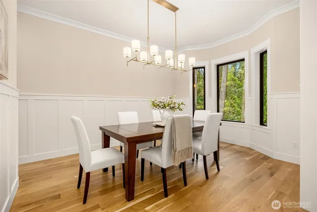 a view of a dining room with furniture a chandelier and wooden floor