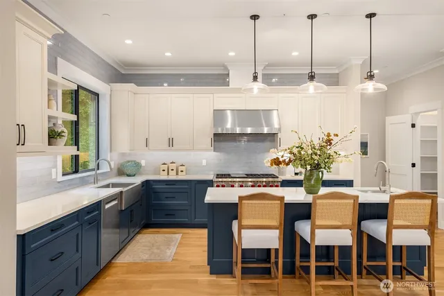 a kitchen with stainless steel appliances kitchen island granite countertop a table chairs sink and cabinets