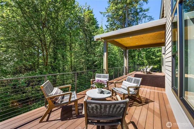 a patio with wooden floor table and chairs