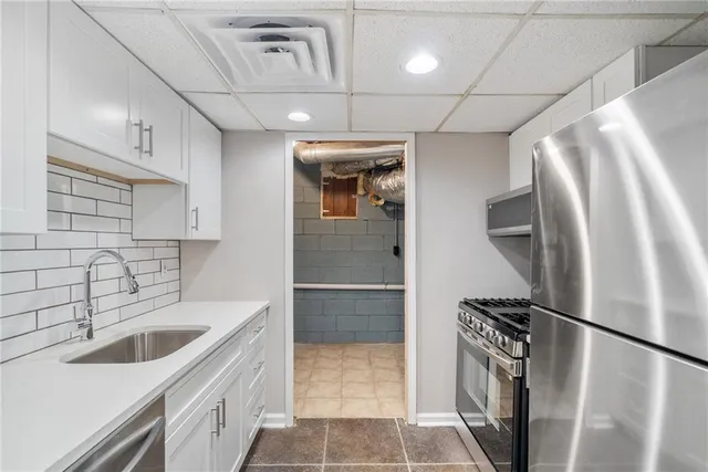 a kitchen with a sink a refrigerator and cabinets