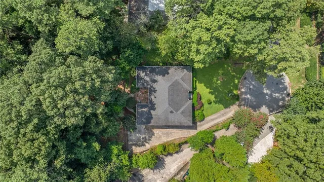 an aerial view of a house with a yard and large tree