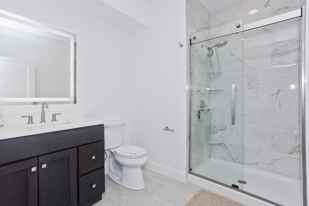 107 Williams Street, Unit 3C Northampton, MA 01060 - Photo 15 of 19 a bathroom with a shower sink vanity mirror and toilet
