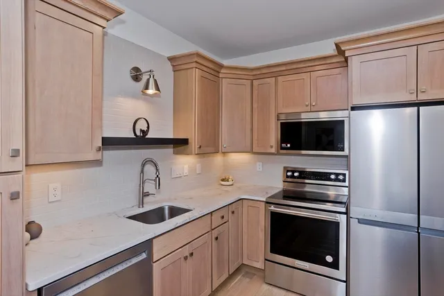 a kitchen with stainless steel appliances a refrigerator sink and microwave
