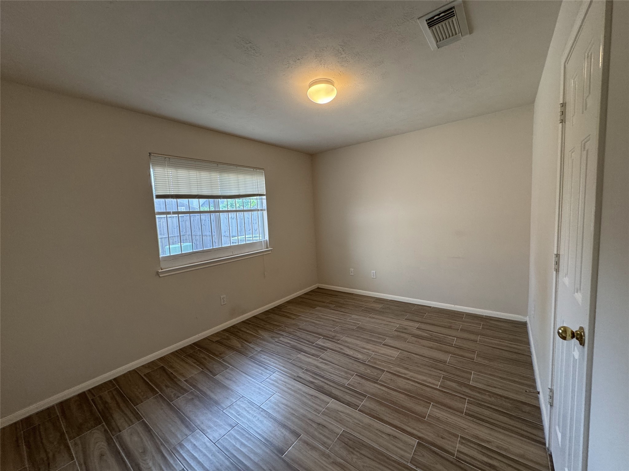 13723 Audra Lane Houston, TX 77083 - Photo 16 of 18 an empty room with wooden floor and windows