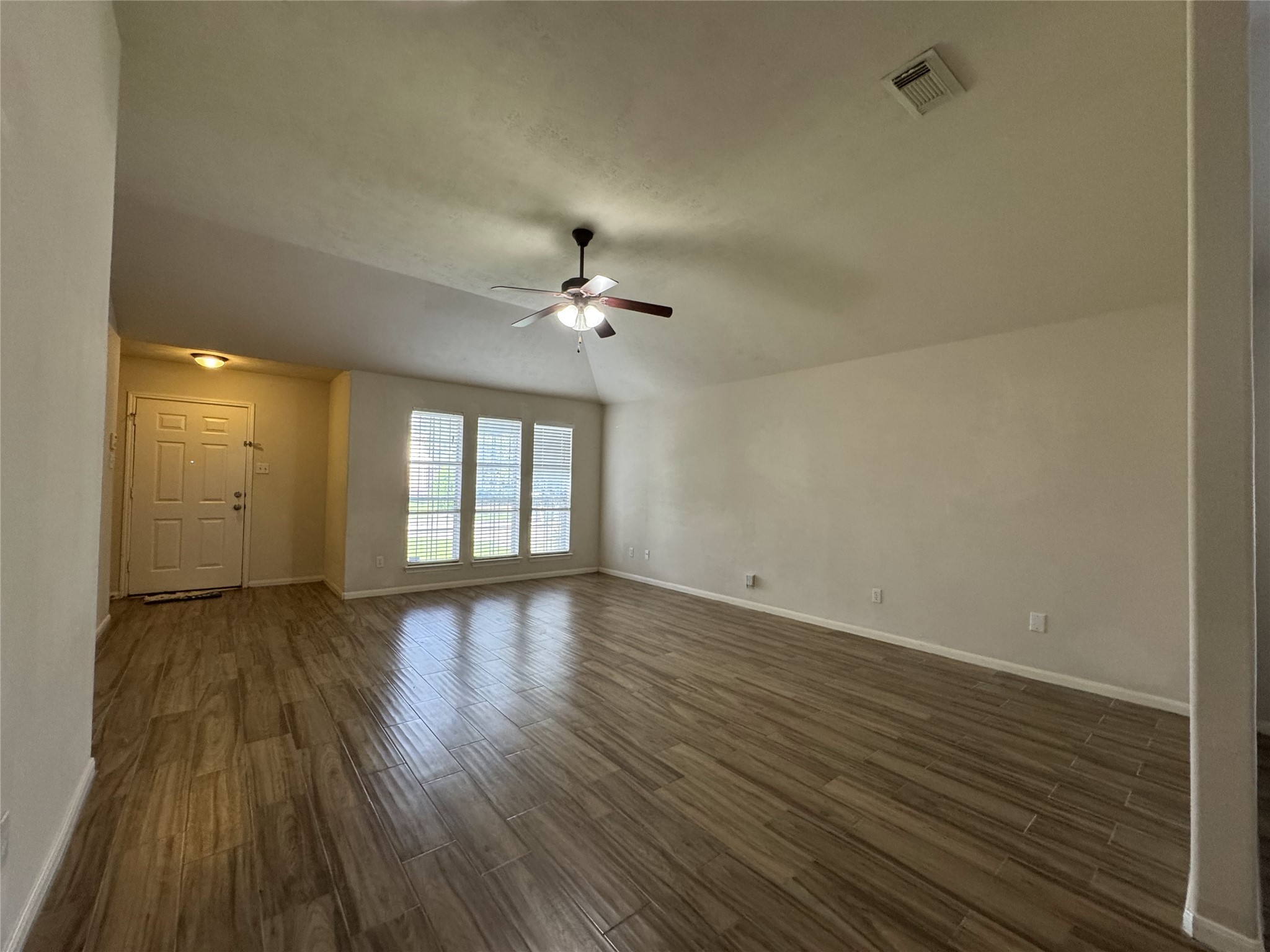 13723 Audra Lane Houston, TX 77083 - Photo 4 of 18 a view of an empty room with wooden floor and a window