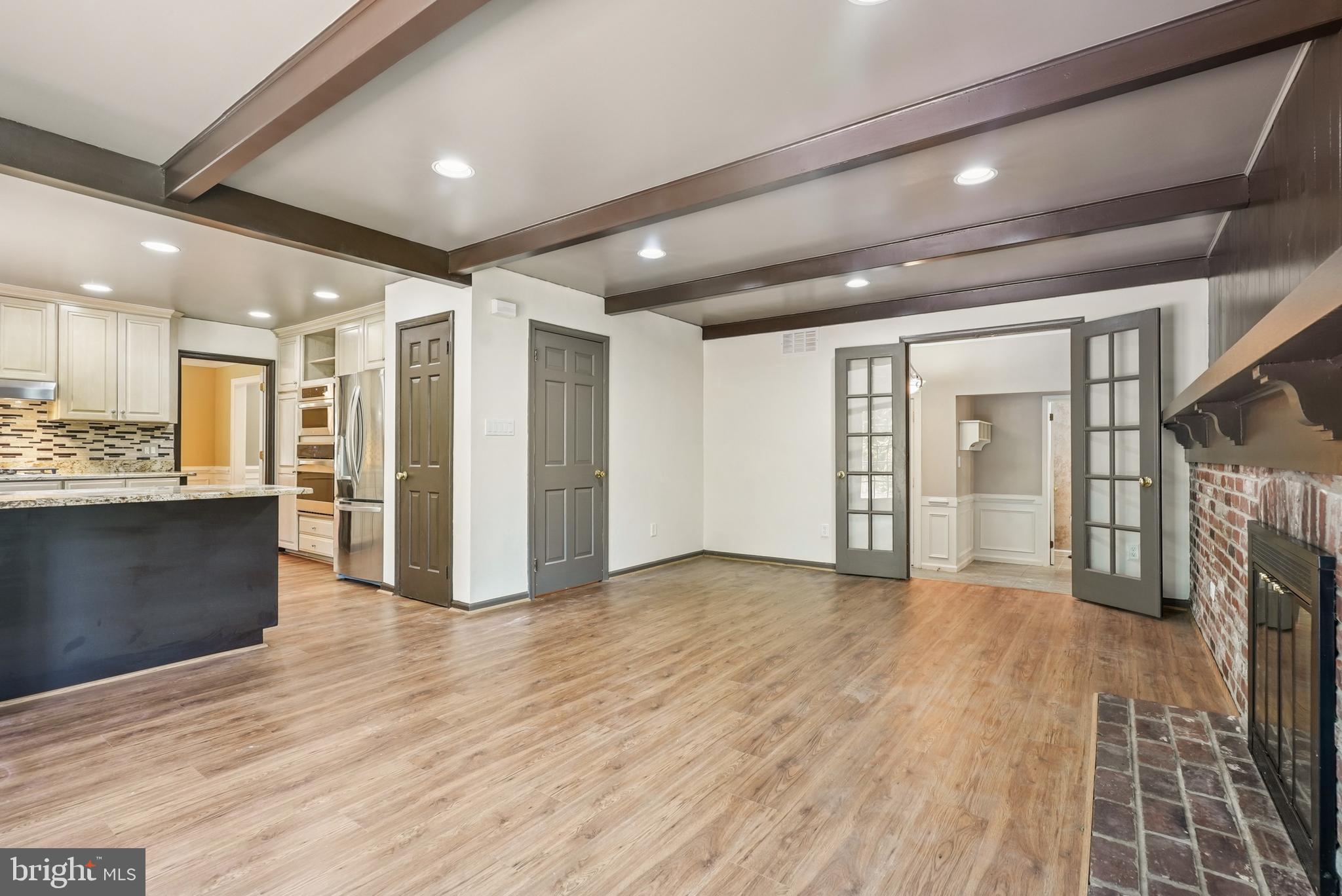 10 Rooftree Road Cherry Hill, NJ 08003 - Photo 10 of 58 a view of an empty room with wooden floor and a kitchen