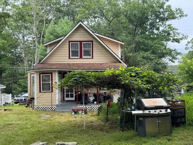 a view of a house with a yard potted plants and a bench