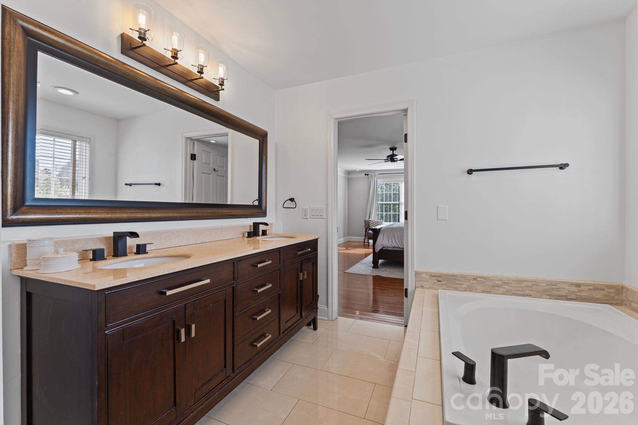 9618 Cockerham Lane Huntersville, NC 28078 - Photo 19 of 37 a spacious bathroom with a double vanity sink a mirror and a bathtub