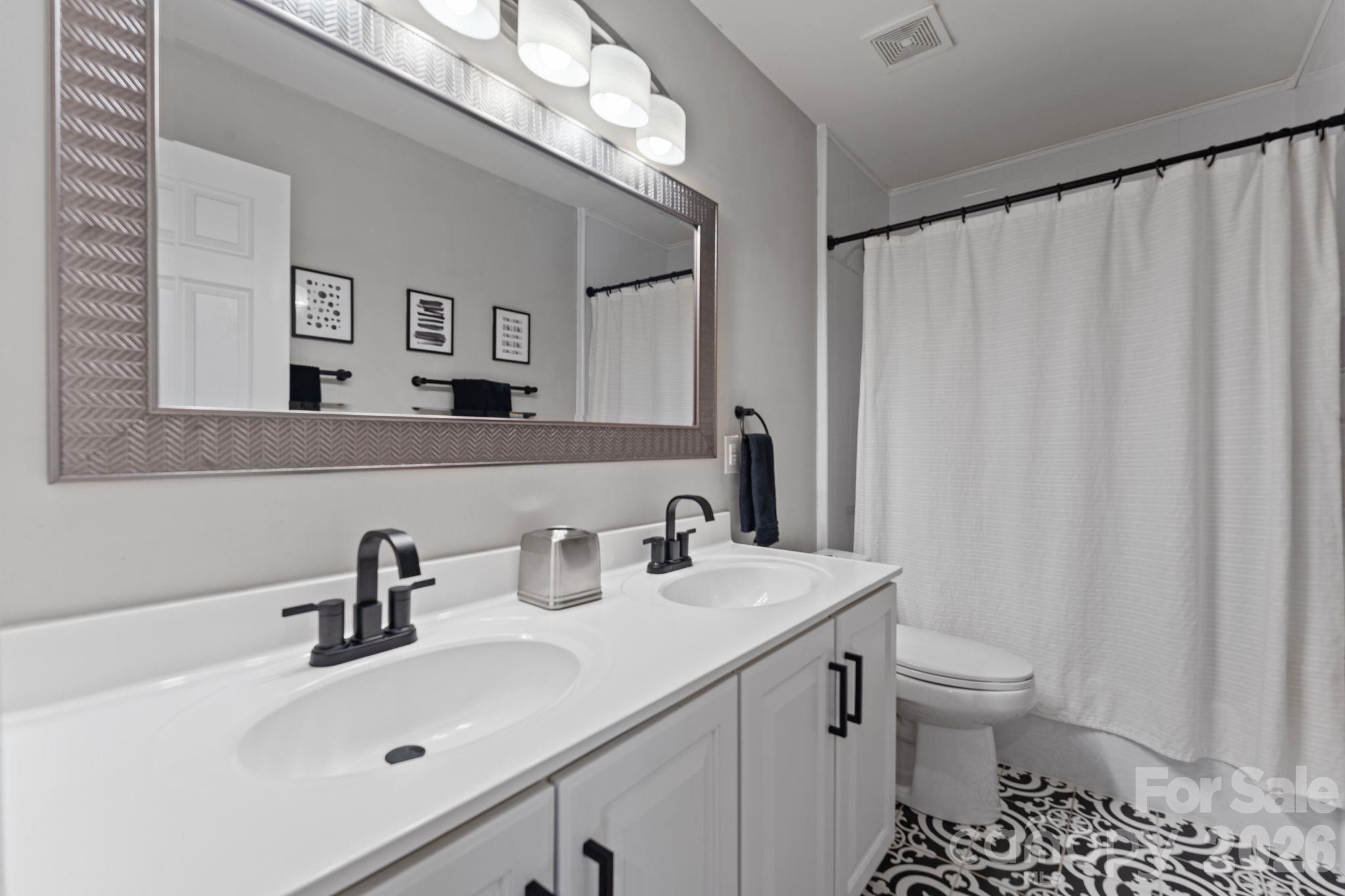 9618 Cockerham Lane Huntersville, NC 28078 - Photo 24 of 37 a bathroom with a sink a toilet and a mirror