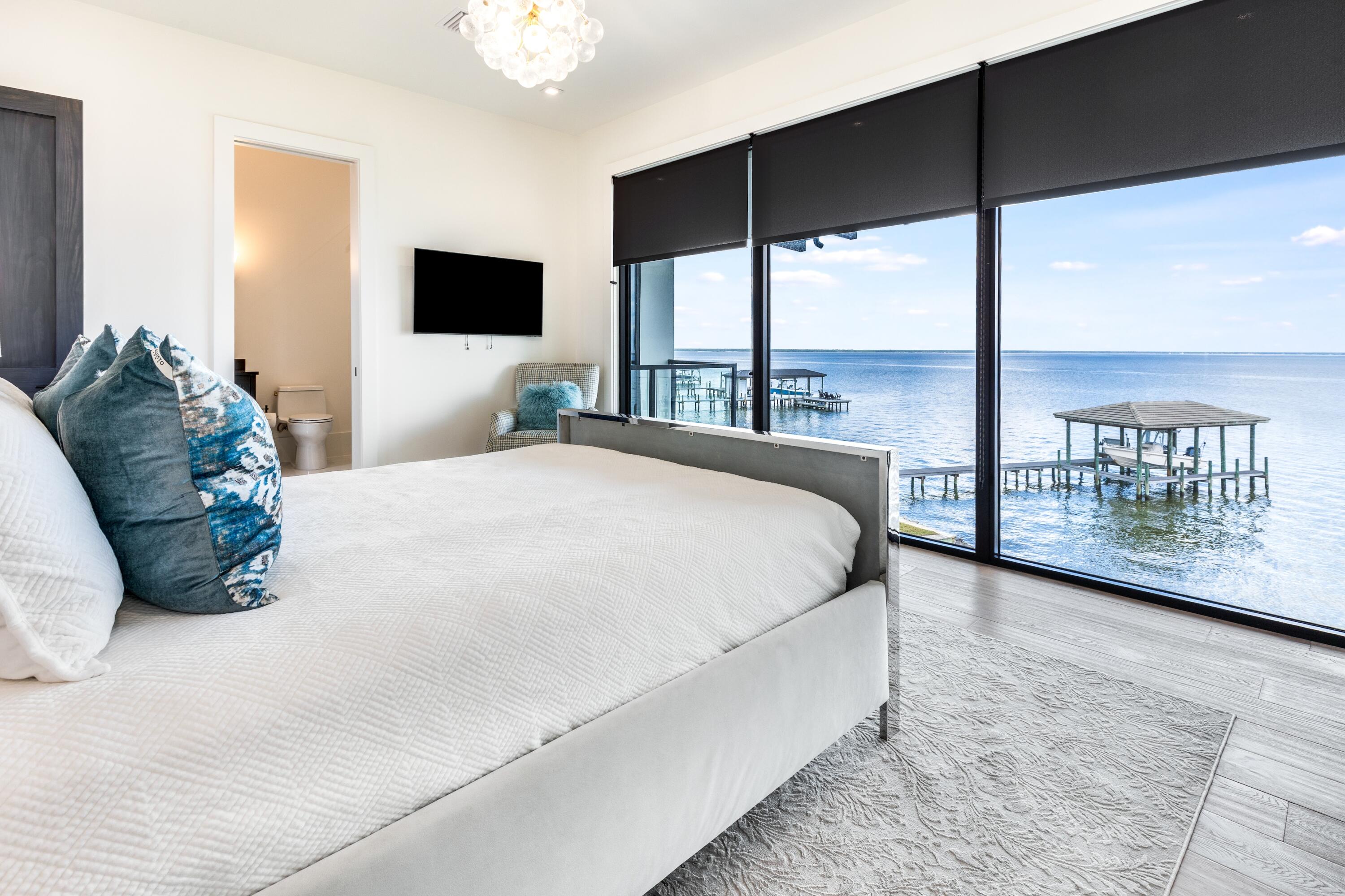 1769 Driftwood Point Road Santa Rosa Beach, FL 32459 - Photo 32 of 70 a spacious bedroom with a large bed and a flat tv screen on dresser
