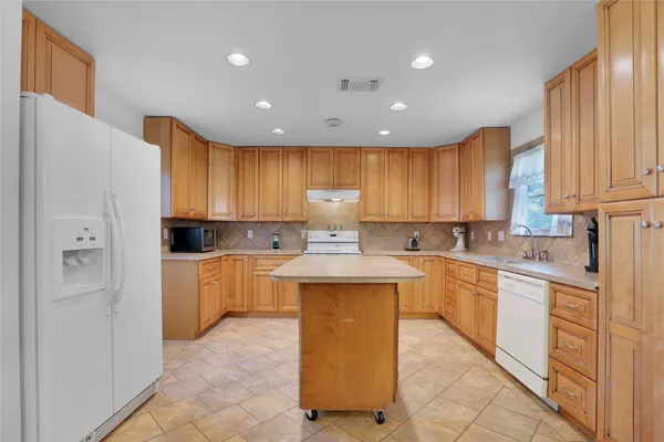 a large kitchen with stainless steel appliances granite countertop a stove a sink dishwasher and a refrigerator