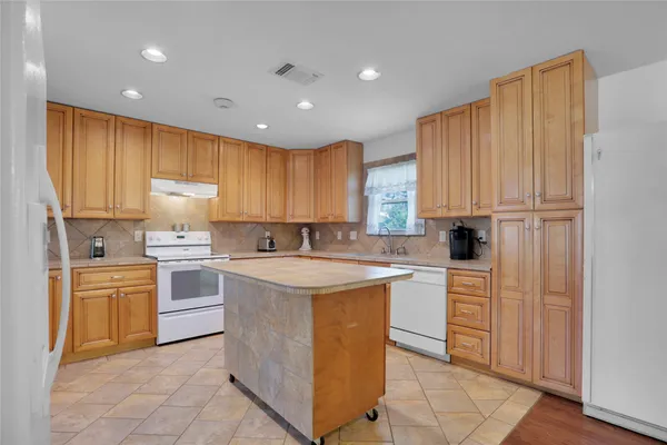 a kitchen with a stove sink and cabinets