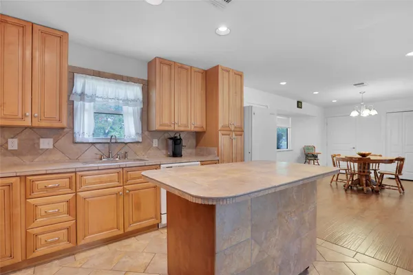a large kitchen with kitchen island a sink table and chairs