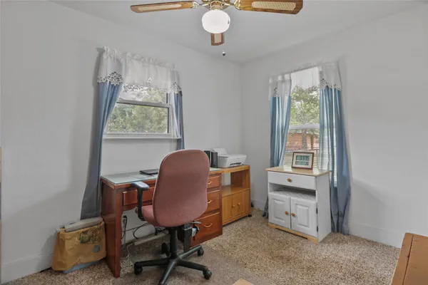 a view of a workspace with furniture and a window