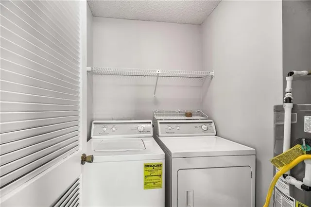 an empty room with chandelier fan and windows