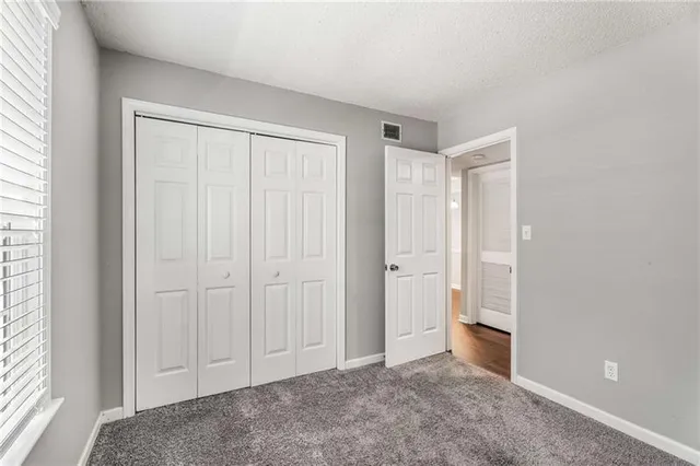 an empty room with closet and a ceiling fan
