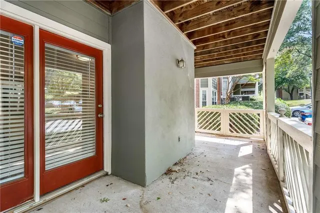 an empty room with wooden floor fireplace and windows
