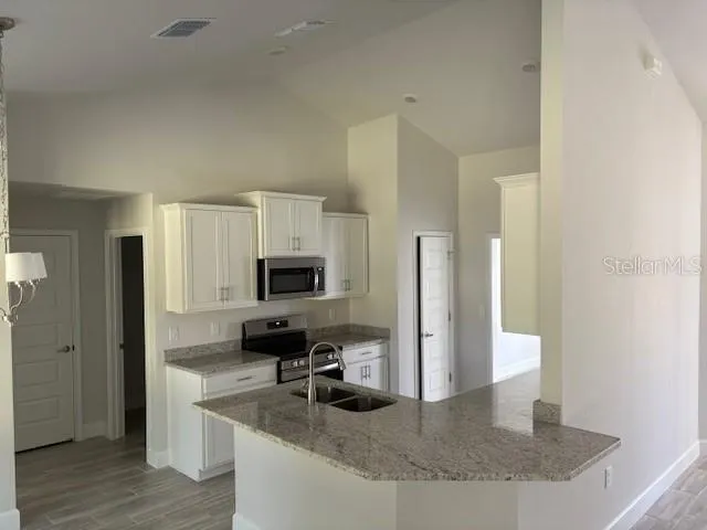a kitchen with sink a refrigerator and a stove