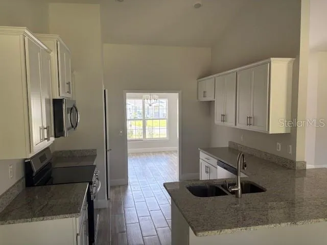 a kitchen with stainless steel appliances granite countertop a sink and a refrigerator