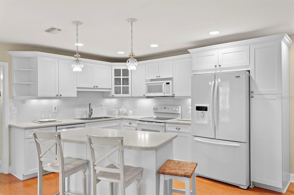 309 Park Ridge Avenue Temple Terrace, FL 33617 - Photo 18 of 60 a kitchen with stainless steel appliances granite countertop a refrigerator a sink dishwasher a stove and white cabinets with wooden floor