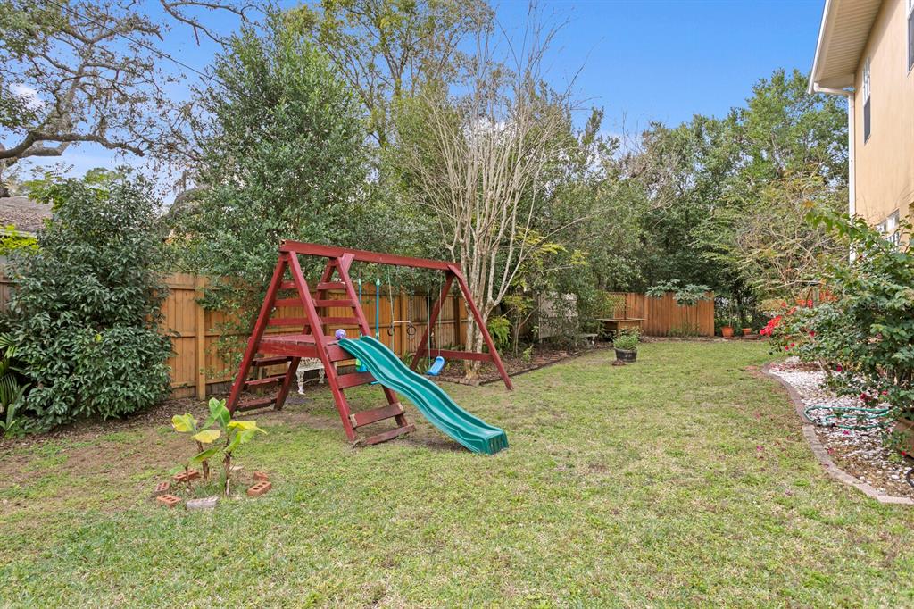 309 Park Ridge Avenue Temple Terrace, FL 33617 - Photo 4 of 60 a backyard of a house with childrens swings and slides