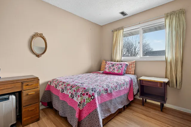 a bed sitting in a bedroom next to a window