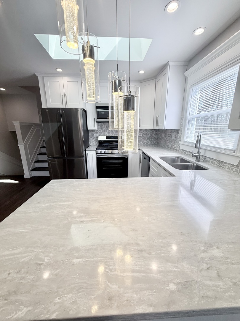 11657 South Racine Avenue Chicago, IL 60643 - Photo 29 of 40 a kitchen with stainless steel appliances kitchen island granite countertop a refrigerator a sink a stove and dishwasher with wooden floor