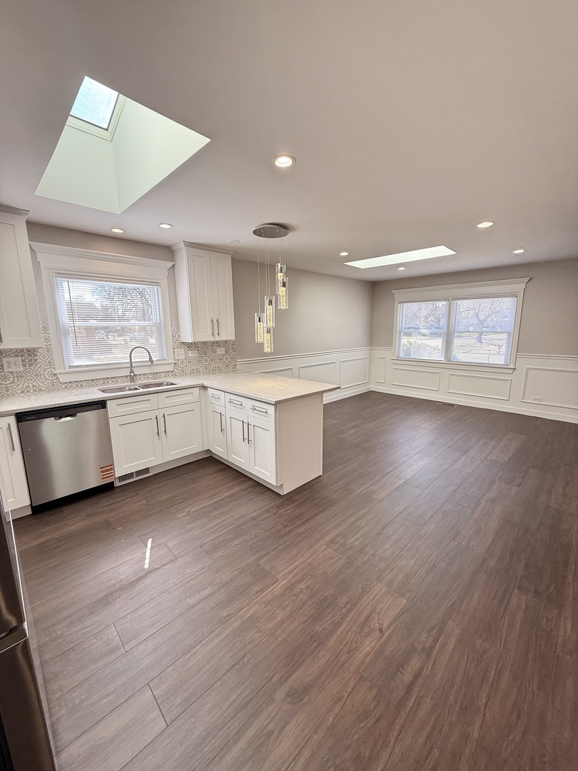 11657 South Racine Avenue Chicago, IL 60643 - Photo 34 of 40 a large kitchen with wooden floors and white cabinets