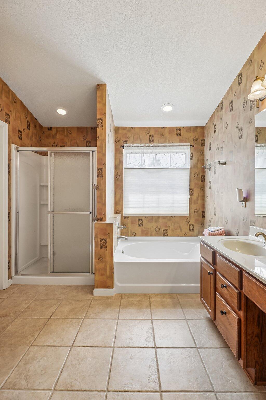 876 Flint Ridge Newport, KY 41076 - Photo 28 of 43 Tile flooring featuring a full bathtub, separate shower enclosure, and a dual-sink vanity with wood-finish cabinetry