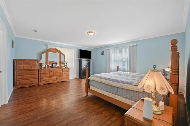 a spacious bedroom with a bed and a dresser