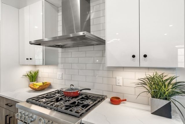 a kitchen with a stove a refrigerator a sink a counter and chairs