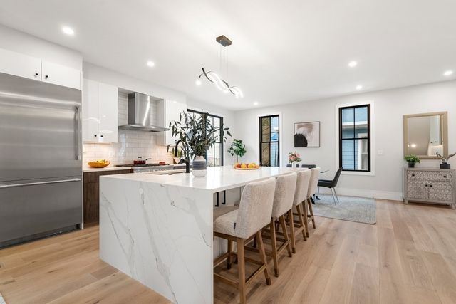 a large kitchen with kitchen island a large counter top space and stainless steel appliances