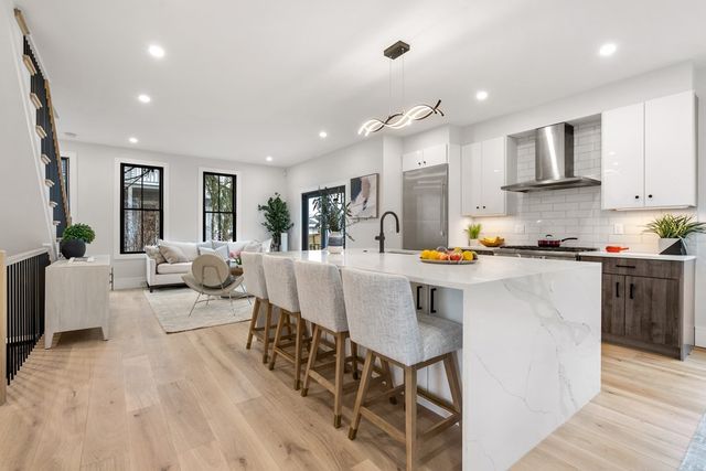 a living room with stainless steel appliances furniture a dining table and chairs