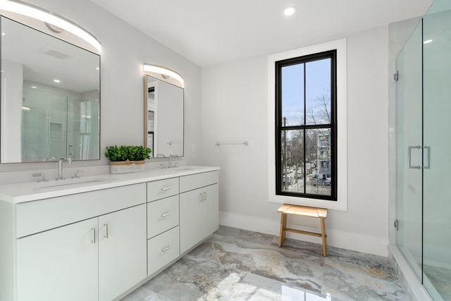 a spacious bathroom with 2 sink and a mirror