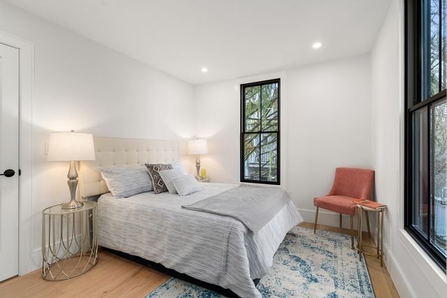 a bedroom with a bed a rug and a chair