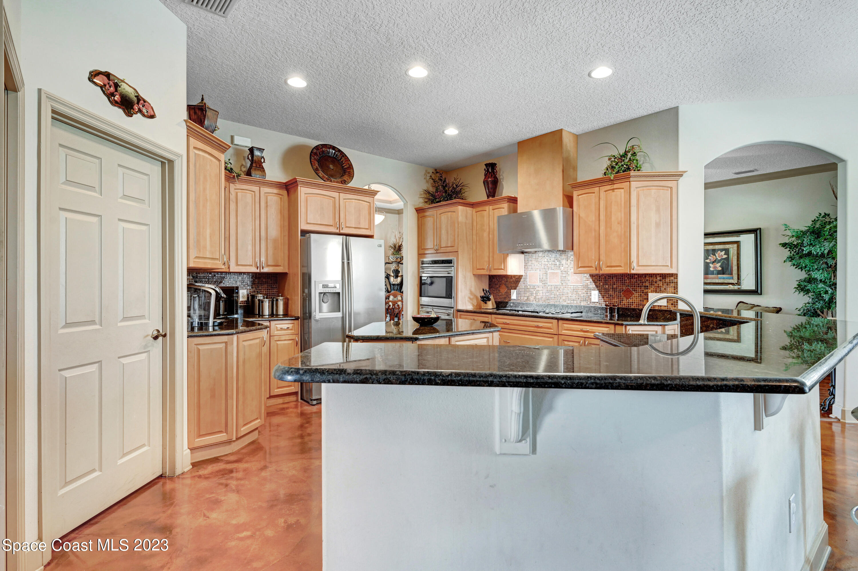 1317 Centennial Way Rockledge, FL 32955 - Photo 12 of 38 a large kitchen with granite countertop a sink stainless steel appliances and cabinets