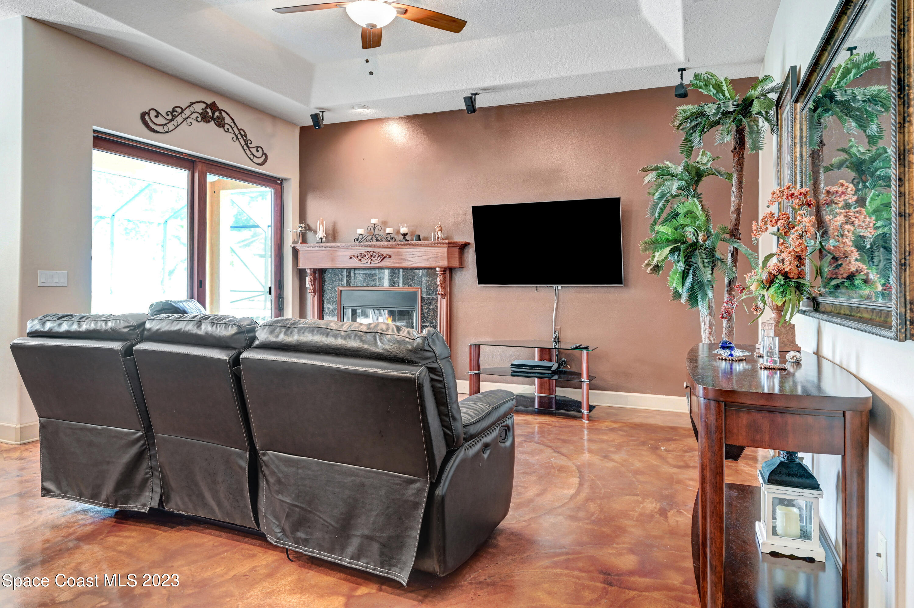 1317 Centennial Way Rockledge, FL 32955 - Photo 16 of 38 a living room with furniture a flat screen tv and a floor to ceiling window