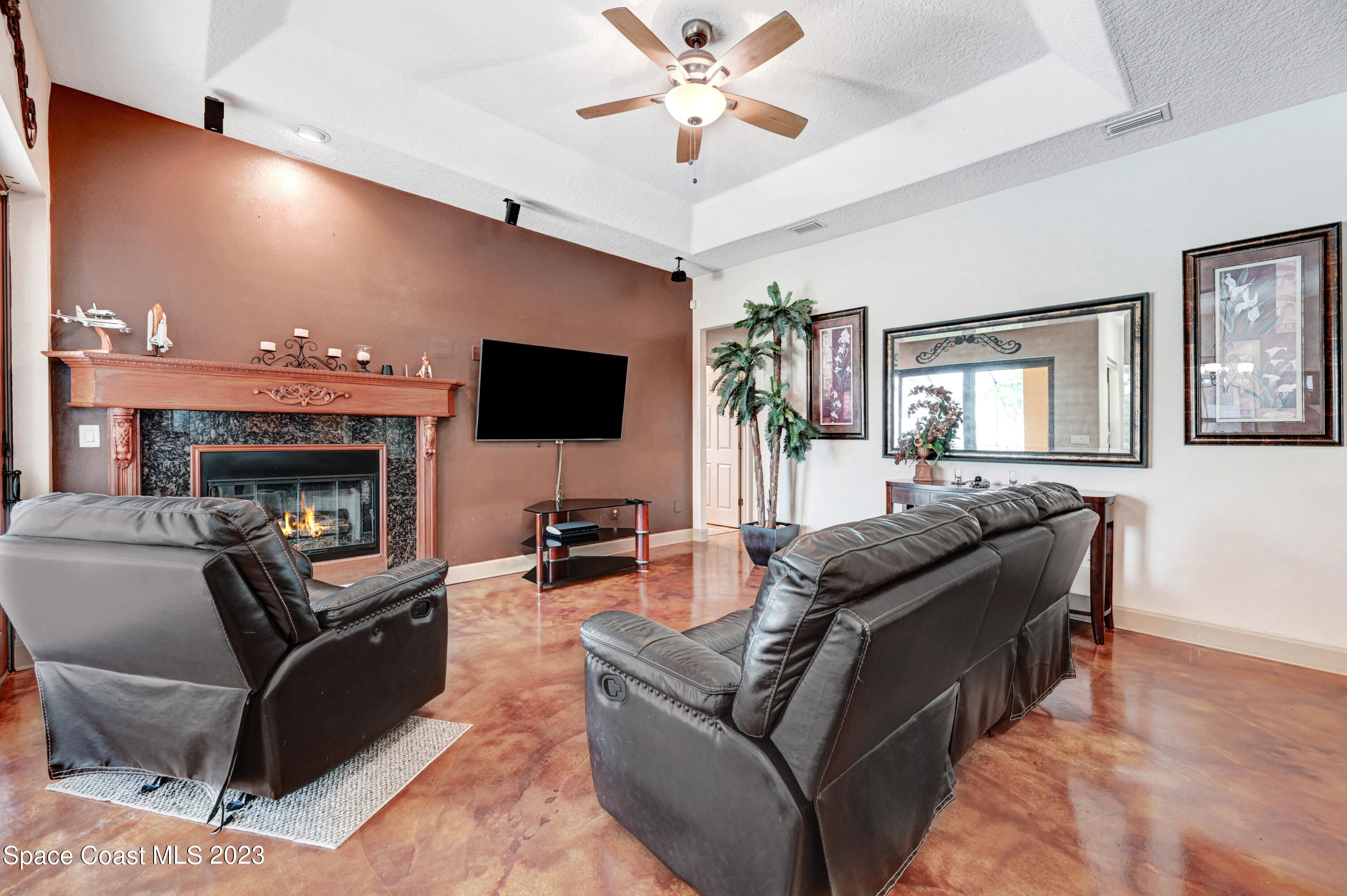 1317 Centennial Way Rockledge, FL 32955 - Photo 17 of 38 a living room with furniture a flat screen tv and a fireplace