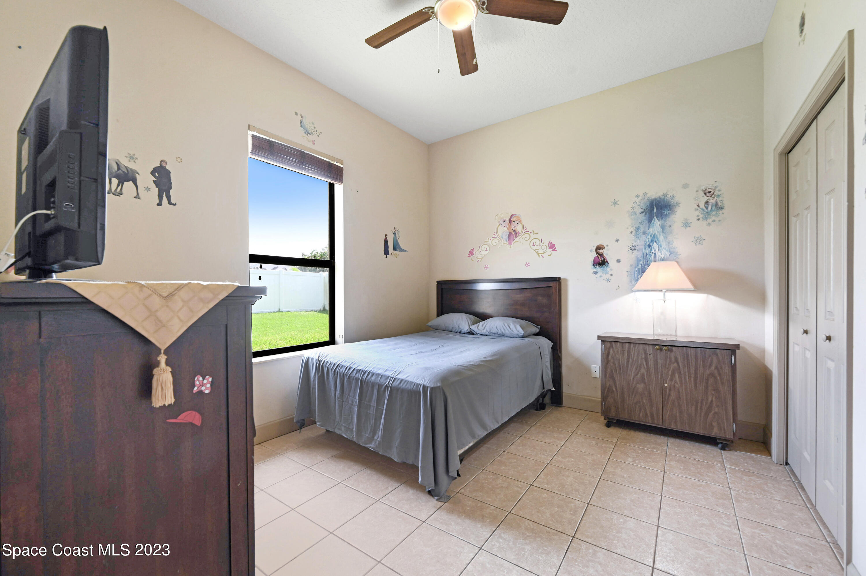 1317 Centennial Way Rockledge, FL 32955 - Photo 26 of 38 a bedroom with a bed and a flat tv screen on dresser