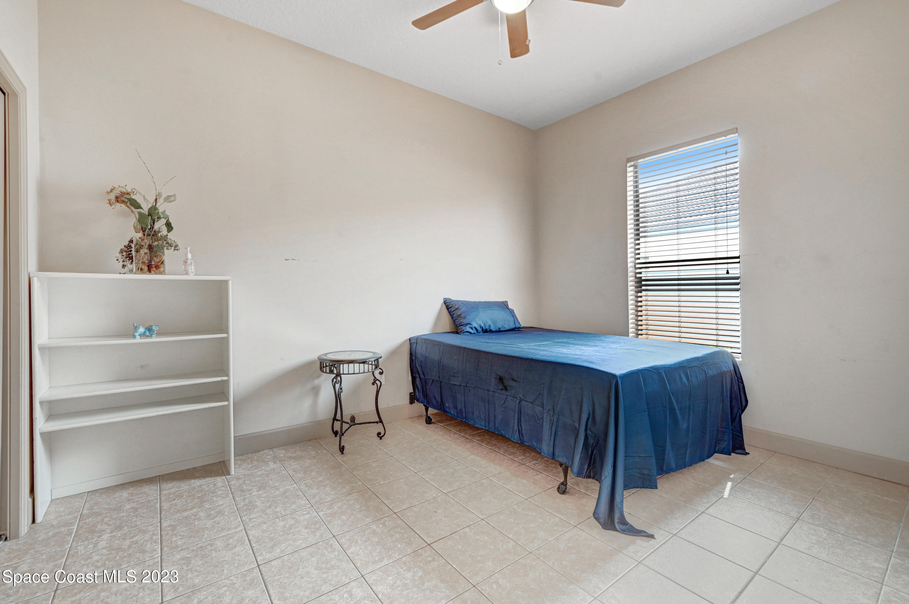 1317 Centennial Way Rockledge, FL 32955 - Photo 27 of 38 a bedroom with a bed and a chandelier