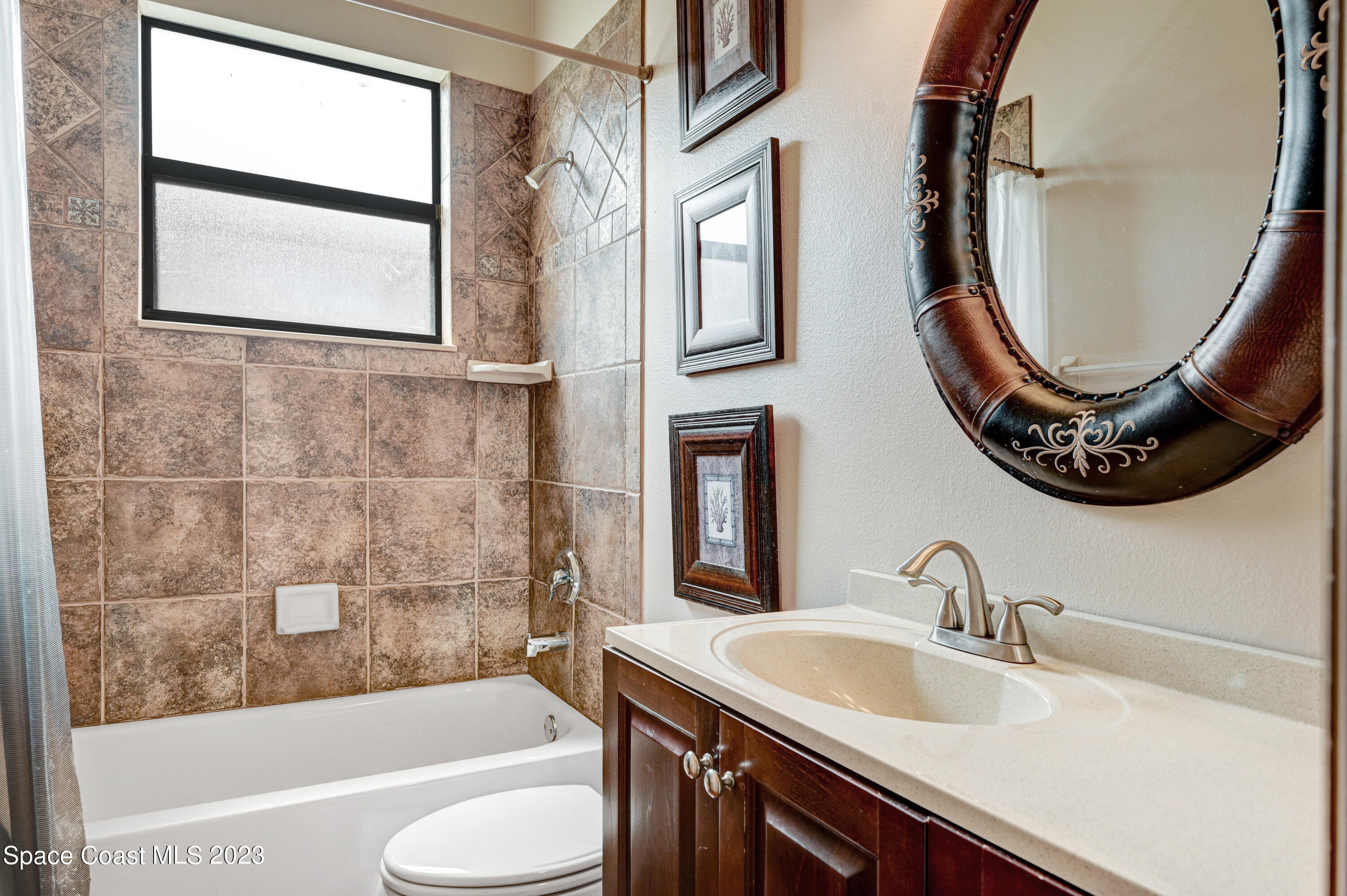 1317 Centennial Way Rockledge, FL 32955 - Photo 29 of 38 a bathroom with a sink a mirror a bathtub and a toilet
