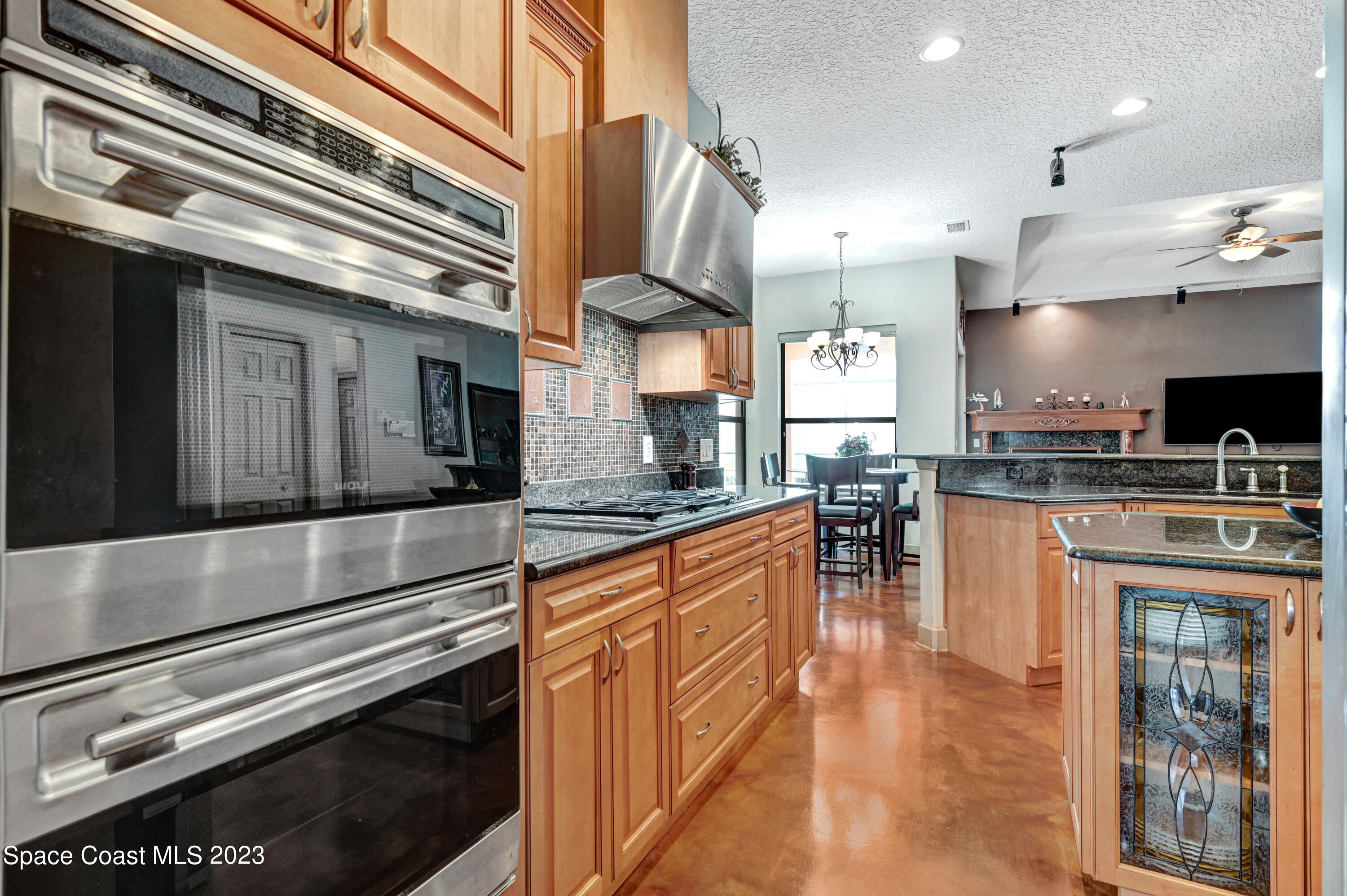 1317 Centennial Way Rockledge, FL 32955 - Photo 7 of 38 a kitchen with stainless steel appliances granite countertop a refrigerator a stove and a wooden floors