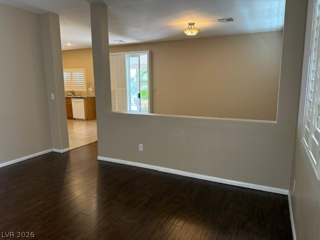 1132 Cathedral Ridge Street Henderson, NV 89052 - Photo 4 of 13 Rich wood flooring connects the open living space, leading to a bright kitchen and outdoor access.