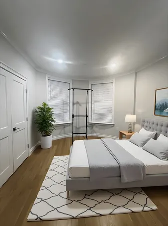 a bedroom with a large bed and a potted plant