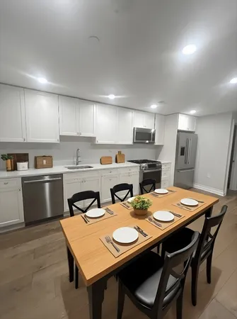 a kitchen with a dining table chairs and refrigerator