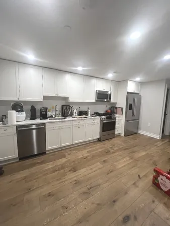 a kitchen with refrigerator a microwave and white cabinets