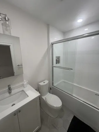 a bathroom with a sink a toilet and shower