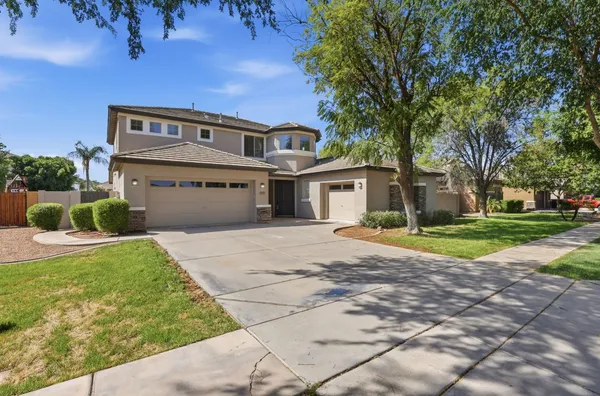 a view of a house with a yard and large tree