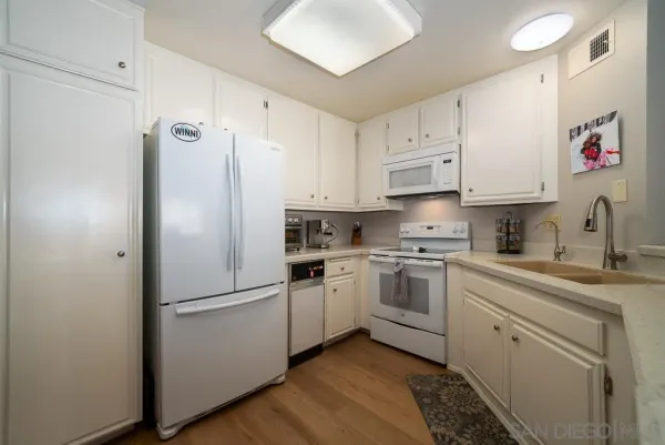 a kitchen with white cabinets and white appliances